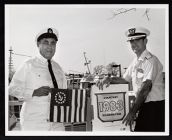 U. S. Coast Guard Auxiliary members with banner and sticker